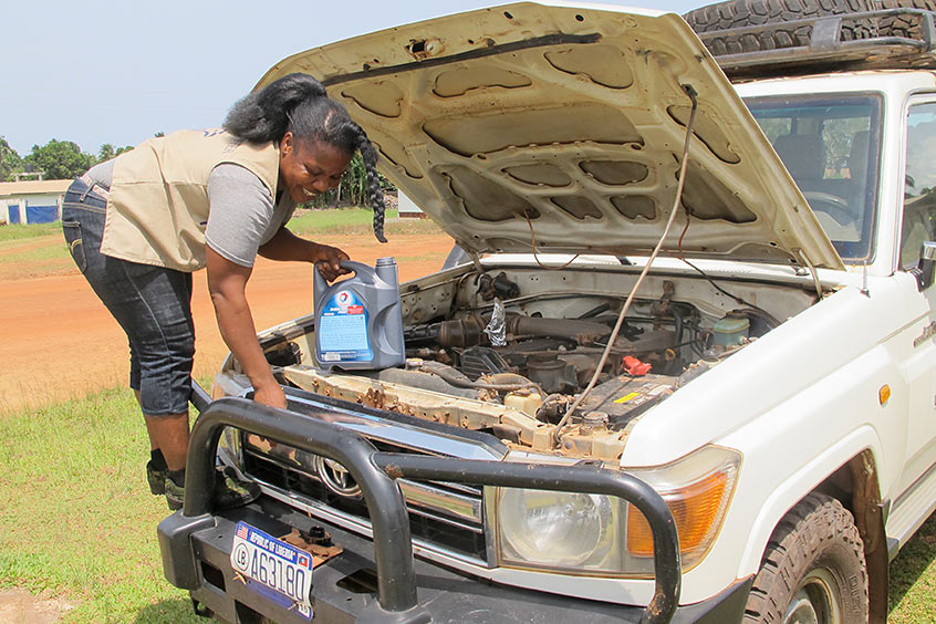 Potential puts oil in a Carter Center vehicle during a trip to Buchanan, where staff were helping lead a training session for women in Grand Bassa County.