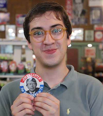 Fabrizio Montisci holds a Jimmy Carter for President button.