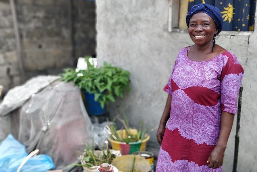 A woman in a purple dress smiles broadly.